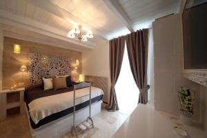 a bedroom with a bed and a large window at Playa del Mar - Adults Only in Monopoli