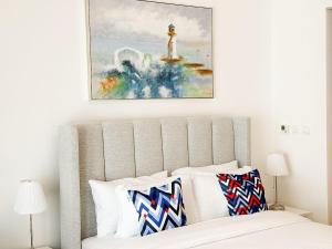 a bedroom with a bed with a painting above it at Yas Island Waters Edge Studio by Central Stay in Abu Dhabi