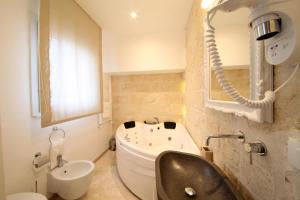 a bathroom with a bath tub and a sink at Playa del Mar - Adults Only in Monopoli