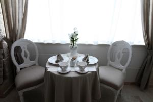 a table with two chairs and a table with plates and cups at Playa del Mar - Adults Only in Monopoli