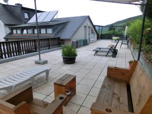 a patio with benches and tables on a building at Ferienwohnung Rivaner in Burg an der Mosel