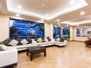 a living room with white couches and a large window at The Agate Pattaya Boutique Resort in Pattaya South