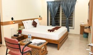a room with a bed and a desk and a microphone at M R Residency Lokapur in Bāgalkot