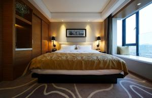Un dormitorio con una cama grande y una ventana en DW Hotel, en Huangshan