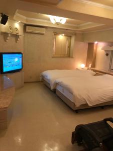岬町にあるホテル龍吉のベッド2台と薄型テレビ付きの部屋