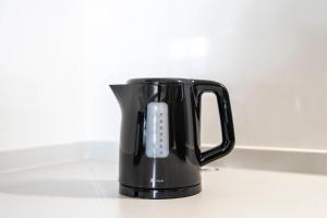 Una cafetera negra con control remoto. en Kotobuki, en Otaru