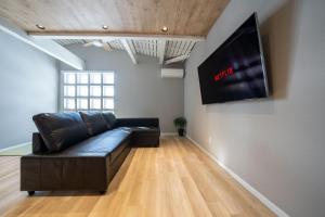 a living room with a black leather couch and a flat screen tv at Kotobuki in Otaru