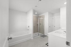 a white bathroom with a tub and a sink at Elegant Townhouse Retreat Near Mall Of Georgia in Buford