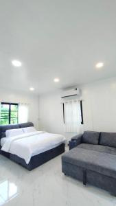 a bedroom with a large bed and a couch at FarmStay Tawanchai ฟาร์มสุขตะวันฉาย YS in Ban Fak Huai
