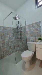 a bathroom with a toilet and a glass shower at FarmStay Tawanchai ฟาร์มสุขตะวันฉาย YS in Ban Fak Huai
