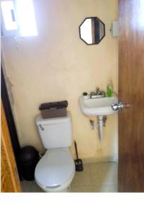 a bathroom with a white toilet and a sink at Casa Rekalde 4 in Izamal