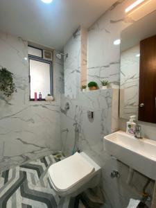 a white bathroom with a sink and a toilet at Modern 2 BR Bandra Trendy Location in Mumbai