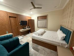 a bedroom with a bed and a couch and a tv at Icon Residency Inn in Prayagraj