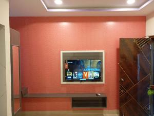 a wall with a flat screen tv on a wall at Aadya Inn New Luxury Hotel in Tirupati