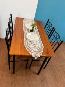 a wooden table with two plates and flowers on it at 1Br 2pax 1car only Malaysian guest only in Bayan Lepas +40 photos