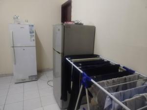 a kitchen with a refrigerator next to a refrigeratorvelt at Muscat Tower in Sharjah