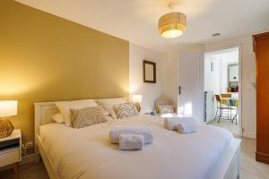 a bedroom with a large white bed with towels on it at La Petite Marjolaine Pretty Garden Level in Vence in Vence