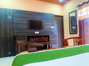 - une chambre avec un lit, un bureau et une télévision dans l'établissement Blackberry Resort Pushkar - Nature with Pool, à Pushkar