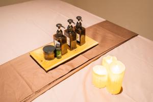 a table with four bottles of essential oils and candles at Loft Baan Sea Nok - Private Living Room, Kitchen, AC - Central Bingin in Uluwatu