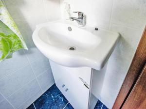 biała umywalka w łazience wyłożonej niebieskimi kafelkami w obiekcie Apartment in Starigrad Paklenica w mieście Starigrad-Paklenica +30 zdjęć