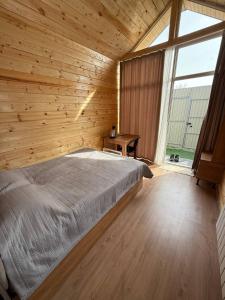 a bedroom with a bed in a wooden room at Абая 29 гостевые домики in Kosh-Tegirmen