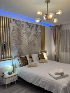 a bedroom with a large white bed with a blue ceiling at Sara Suite in Sibiu