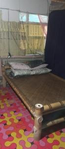 a bed in a room with a colorful carpet at Payag Ni Bodeng in Talusan