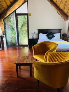 a bedroom with a bed and a chair and a table at GEORGE B BOUTIQUE LODGE in Tzaneen +59 photos