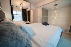 Ένα ή περισσότερα κρεβάτια σε δωμάτιο στο 2 Level 1 Bedroom Lux Apartment with Balcony 75 Inch TV and Sofa Bed near Promenada Mall with High Ceilings Kitchen Washer and Work Space