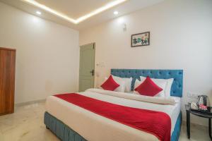 a bedroom with a large bed with red pillows at Hotel The Hidden Door-Near Jaipur Airport in Jaipur