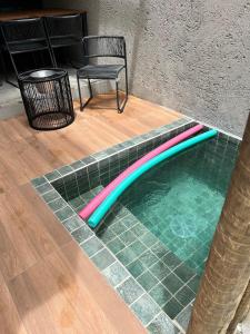 a swimming pool with a chair and a table at Casa en Milagres com piscina 600 metros da praia in São Miguel dos Milagres