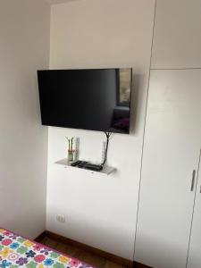 een tv aan een muur met een spiegel erop bij Apartment Rosi Beach & Pool Punta Hermosa in Punta Hermosa