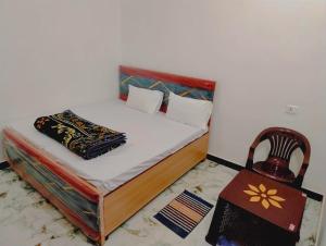 a small bed in a room with a chair at Sri Sitaram Hnuman Ji Guest House in Ayodhya +17 photos
