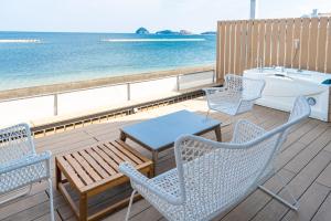 a deck with chairs and a table and a tub at Beach SPA TSUDA 2Dos棟 3Tres棟 in Sanuki