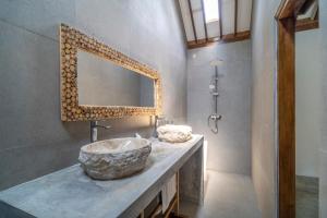 un bagno con un lavandino in pietra e uno specchio di Saltwater Villa And Spa a Gili Trawangan