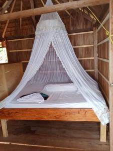 Ce lit se trouve dans un dortoir doté d'une moustiquaire. dans l'établissement Warfanin Homestay, à Pulau Gam