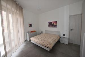 Un dormitorio blanco con una cama y una ventana. en Appartamento casa Ammare, en Montesilvano