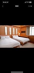 twee bedden in een grote kamer met ramen bij BARi OKINAWA in Itoman +13 foto's