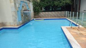 a swimming pool with blue water in a building at Hostel Leandros Eldorado in Contagem