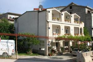 a large white building with a balcony on top of it at House Roso in Makarska