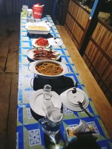 une table avec plusieurs assiettes de nourriture dessus dans l'établissement Warfanin Homestay, à Pulau Gam