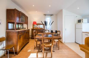 a kitchen and dining room with a wooden table and chairs at Villa Margot fibre balcon jardin in Millau +16 photos