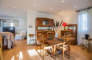 a dining room with a table and chairs and a bedroom at Villa Margot fibre balcon jardin in Millau