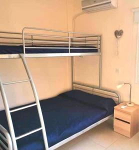 a bedroom with two bunk beds with a blue mattress at Ionian Breeze Family House Walk to Beach And Dining in Paralimni +41 photos
