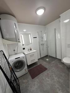 a bathroom with a washing machine and a sink at Central apartment from 2025 in Alta