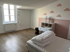 una camera da letto con un letto, una sedia e una finestra di Grand duplex centre historique a La Rochelle