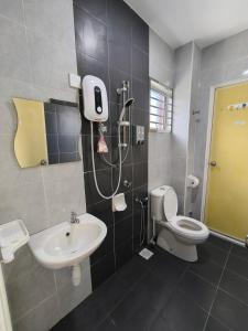 a bathroom with a shower and a toilet and a sink at Putera Indah Homestay Batu Pahat 13 pax by Ngio in Batu Pahat