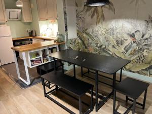 una cucina con tavolo nero e sedie di Grand duplex centre historique a La Rochelle