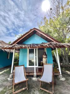 Eine Frau steht im Fenster eines blauen Hauses in der Unterkunft My Island Casitas in Baclayon
