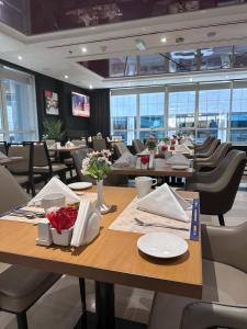 a dining room with tables and chairs in a restaurant at Al Diar Sawa Hotel Apartments in Abu Dhabi